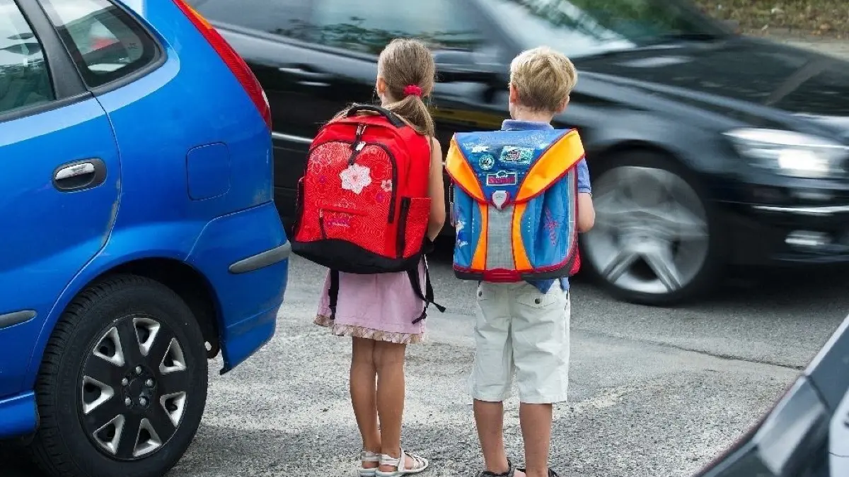 ARCHIV - 30.07.2013, Brandenburg, Frankfurt (Oder): ILLUSTRATION: Die beiden zukünftigen Erstklässler Amy und Luca üben das Verhalten auf dem Schulweg und das richtige Überqueren einer Straße. Elterntaxi stehenlassen. Unter diesem Motto werben das Deutsche Kinderhilfswerk und der Verkehrsclub Deutschland ab 17.09.2018 für andere Wege zur Schule. Denn mit der steigenden Zahl der Mama- und Papa-Chauffeure nimmt das Risiko von Staus und Unfällen vor Schulen zu. (zu dpa "Zu Fuß zur Schule - Elterntaxis können zur Unfallgefahr werden" vom 16.09.2018) Foto: Patrick Pleul/dpa-Zentralbild/dpa +++ dpa-Bildfunk +++