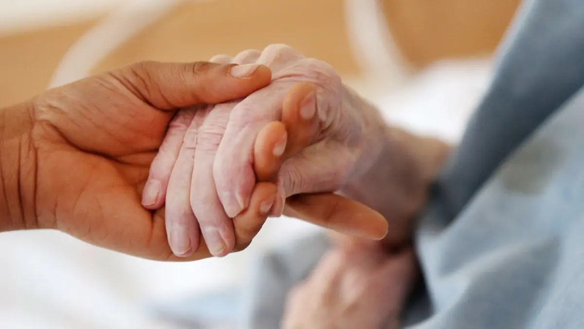 Hilfe gegen Hilfe? Vermittlungsagenturen von 24-Stunden-Pflegekräften aus Osteuropa warnen davor, dass die Not von ukrainischen Geflüchteten ausgenutzt werden könnte, indem sie inoffiziell als Pflegerinnen angestellt werden. Doch wie verbreitet ist das Phänomen in Brandenburg?
ILLUSTRATION - Eine Pflegerin hält die Hand einer Altenheim-Bewohnerin. Heimbewohner in Nordrhein-Westfalen müssen für die Pflege nach einer Studie deutlich tiefer in die Tasche greifen als noch vor einem Jahr. Der Eigenanteil für die Pflegeleistungen erhöhte sich im bevölkerungsreichsten Bundesland von 691 Euro im vergangenen auf 755 Euro in diesem Jahr, wie eine Auswertung des arbeitgebernahen Instituts der deutschen Wirtschaft (IW) ergab - ein Plus von 9,3 Prozent. +++ dpa-Bildfunk +++
