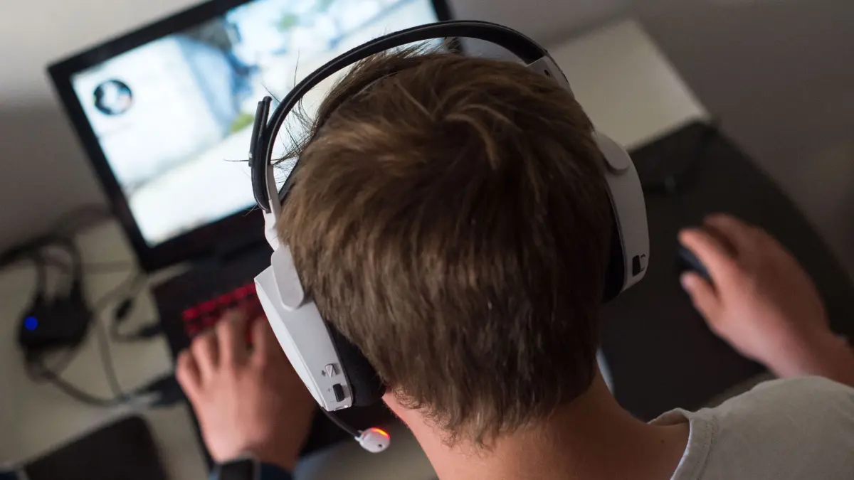 Computerspielen: ARCHIV - 17.06.2017, Berlin: Ein Jugendlicher sitzt mit einem Headset vor einem Laptop und spielt ein Online-Computerspiel. (zu dpa: «Der Ukraine-Krieg als Computerspiel: «Es ist Propaganda»») Foto: Lino Mirgeler/dpa +++ dpa-Bildfunk +++