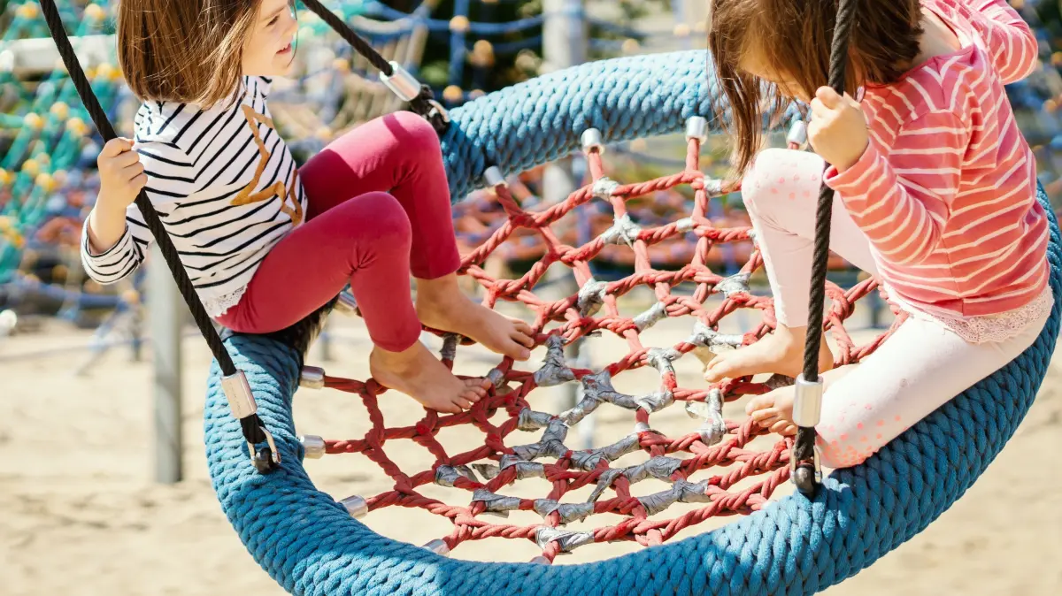 Symbolbild, Symbolfoto, Kinder, Mädchen, Spielplatz, Kindergarten, spielen, schaukeln, Schaukel, Ferien, Kinderbetreuung, Kita, Ferienfreizeit Foto:© superelaks/stock.adobe.comm