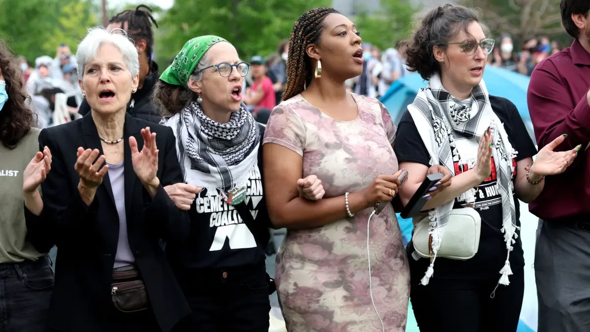 Nahostkonflikt — Proteste an US–Unis: 27.04.2024, USA, St. Louis: Die Präsidentschaftskandidatin der Grünen Partei, Jill Stein, links, Arm in Arm mit anderen, darunter die Stadträtin Alisha Sonnier, zweite von rechts, und die Stadtratsvorsitzende Megan Green, rechts, während sie vor propalästinensische Demonstranten stehen, als die Polizei zu deren Lager auf dem Campus der Washington University kommt. Foto: Christine Tannous/St. Louis Post-Dispatch/AP/dpa +++ dpa-Bildfunk +++
