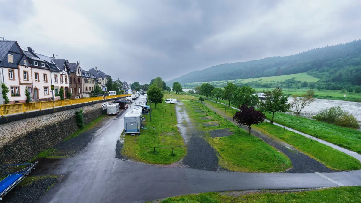 Wasserpegel der Mosel steigt an: 17.05.2024, Rheinland-Pfalz, Zeltingen-Rachtig: Die Stellflächen im Ufernähe des Wohnmobilstellplatz Zeltingen mussten geräumt werden. Die Wohnmobile können zur Zeit noch auf einem höher gelegenen Teil des Stellplatzes verbleiben. Das Hochwassermeldezentrum schätzt, dass der Pegelstand der Mosel bis Sonntag auf 7,30 Meter steigt. Dann wäre auch die B49 am Flußufer überschwemmt und müsste gesperrt werden. Das Wasser würde dann auch die Altstadt von Cochem erreichen. Einigen Stellflächen für Wohnmobile und Campingwagen in Ufernähe der Mosel mussten geräumt werden. Foto: Andreas Arnold/dpa - ACHTUNG: Kennzeichen wurden aus rechtlichen Gründen gepixelt +++ dpa-Bildfunk +++