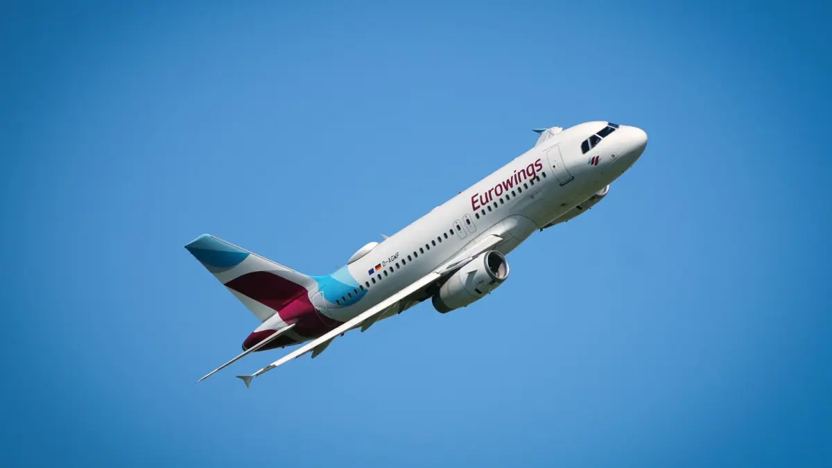 Abflug vom Berliner Flughafen BER: ARCHIV - 13.05.2024, Brandenburg, Schönefeld: Ein Airbus A319 (Registrierung D-AGWF) der Fluggesellschaft Eurowings fliegt vom Flughafen Berlin Brandenburg (BER) kommend nahe Waltersdorf nach dem Start die sogenannte Hoffmannkurve. Mit dem Flugmanöver nach rechts vermeidet der Pilot das Überfliegen dicht bewohnter Gebiete. (zu dpa: «Auch bei Eurowings werden die Flugtickets teurer») Foto: Soeren Stache/dpa +++ dpa-Bildfunk +++