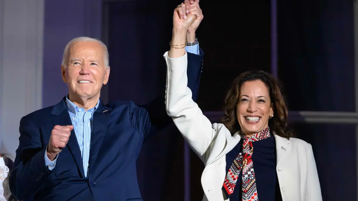 (FILES) US President Joe Biden (L) and US Vice President Kamala Harris hold hands and gesture as they watch the Independence Day fireworks display from the Truman Balcony of the White House in Washington, DC, on July 4, 2024. US President Joe Biden announced July 21, 2024 that he is dropping out of his reelection battle with Donald Trump, in a historic move that plunges the already turbulent 2024 White House race into uncharted territory. Biden also said he was endorsing Vice President Kamala Harris as the Democratic nominee for the 2024 election after he dropped out of the race. (Photo by Mandel NGAN / AFP)