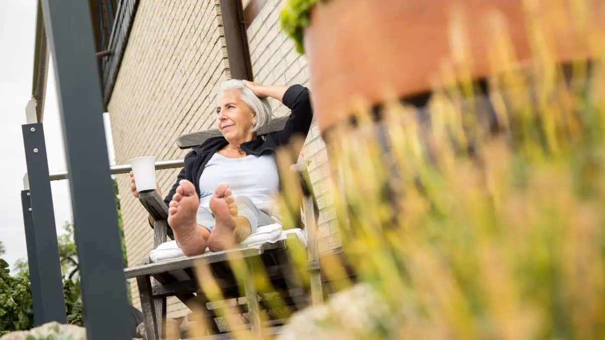 Eine Frau sitzt in einem Garten: ILLUSTRATION - Ein Moment für mich! Sich selbst das süße Nichtstun zu gönnen, das müssen manche Menschen erstmal lernen. (zu dpa: «So können ältere Menschen Selbstfürsorge lernen») Foto: Christin Klose/dpa-tmn - Honorarfrei nur für Bezieher des dpa-Themendienstes +++ dpa-Themendienst +++