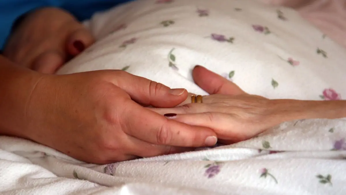 ARCHIV - 28.11.2018, Sachsen-Anhalt, Stendal: Die Hände einer Bewohnerin liegen in einem Hospiz auf einer Bettdecke. (zu dpa: «Ermittlungen gegen Palliativarzt - Motiv unklar») Foto: Peter Förster/dpa-Zentralbild/dpa +++ dpa-Bildfunk +++