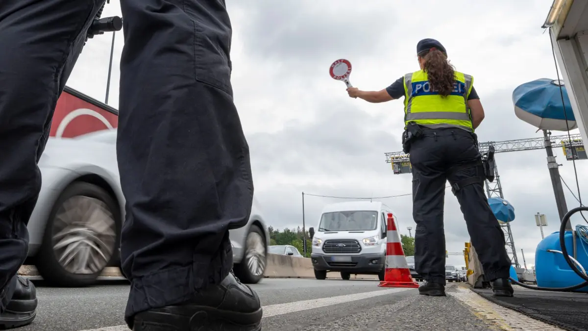 Grenzkontrollen Bundespolizei an A8: PRODUKTION - 20.08.2024, Österreich, Walserberg: Polizisten stehen bei Grenzkontrollen der Bundespolizei am Grenzübergang zwischen Österreich und Deutschland an der Autobahn A8 nahe Salzburg (Österreich). (zu dpa: «Illegale Migration 2023 deutlich gestiegen») Foto: Peter Kneffel/dpa +++ dpa-Bildfunk +++