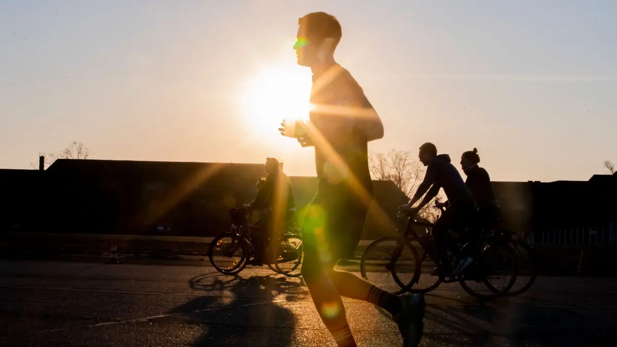 Ein Jogger im Gegenlicht: ILLUSTRATION - Spaß an der Bewegung: Damit Fußgänger und Radler gesund und sicher unterwegs sind, erfordert es umsichtiges Verhalten von allen Seiten. (zu dpa: «Radfahrer muss Jogger Schmerzensgeld bezahlen») Foto: Christoph Soeder/dpa/dpa-tmn - Honorarfrei nur für Bezieher des dpa-Themendienstes +++ dpa-Themendienst +++