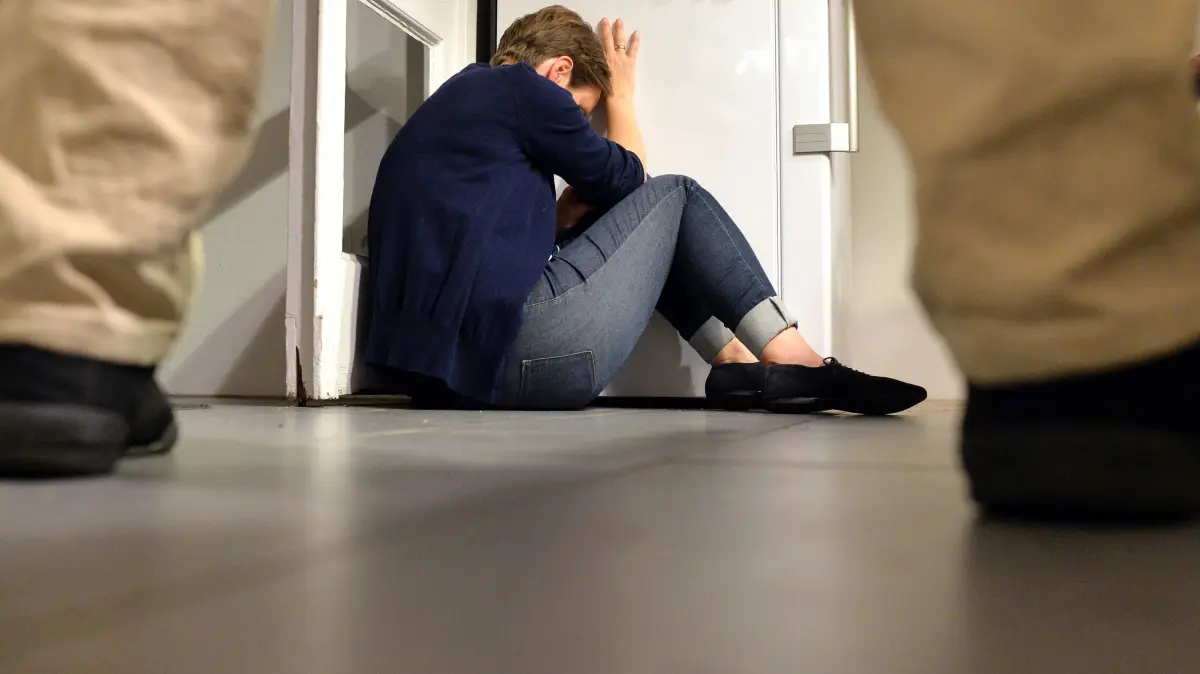 ARCHIV - Ein Mann steht breitbeinig vor einer Frau, die am Boden sitzt. (gestelltes Foto - zu dpa Vorausmeldung "Neue Daten zu Gewalt in der Partnerschaft - Einiges bleibt im Dunkeln") +++ dpa-Bildfunk +++