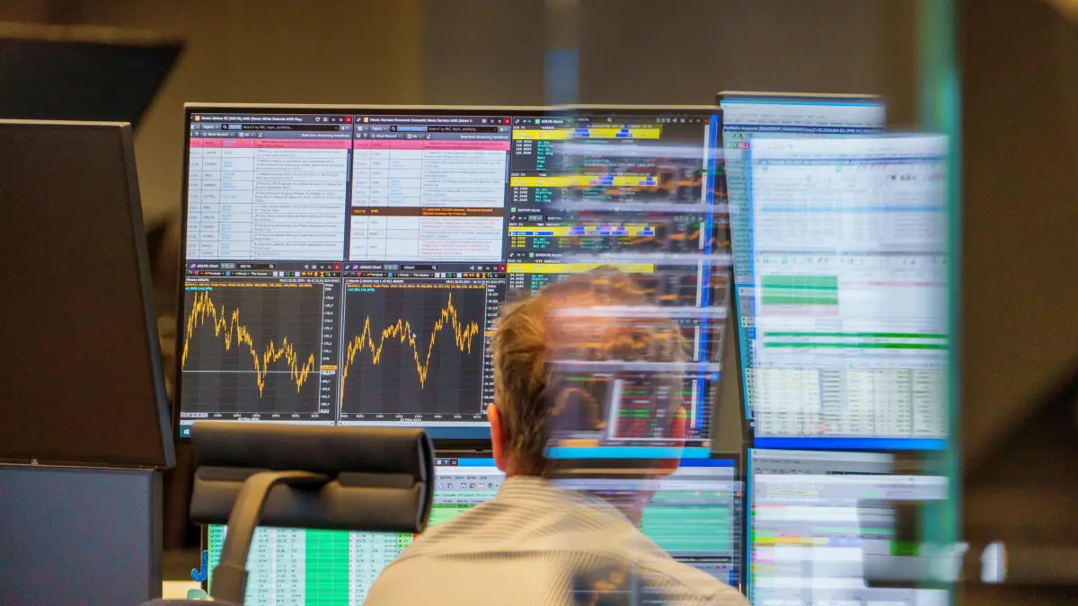 Ein Händler schaut auf seine Bildschirme. Auch zum Wochenausklang hält die Rekordjagd beim Dax an. Der deutsche Leitindex übersprang erstmals 18.200 Punkte. +++ dpa-Bildfunk +++