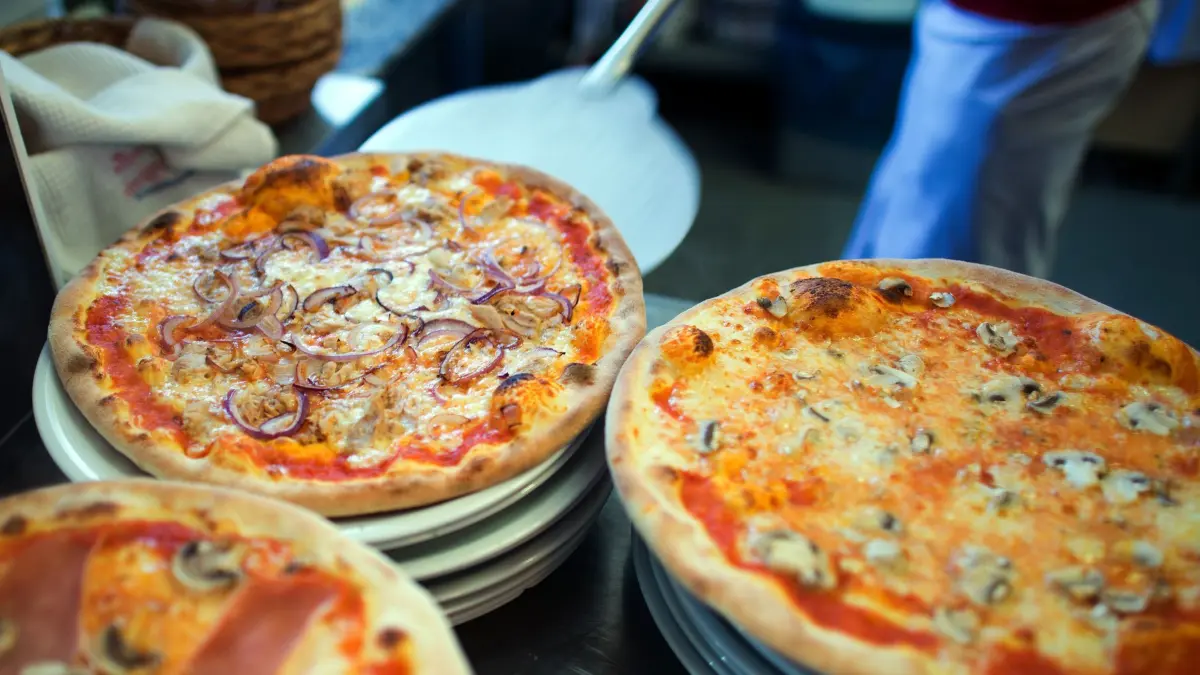 Pizzawoche: ILLUSTRATION - 10.02.2014, Berlin: In einer Pizzeria liegen fertige Pizzen auf Tellern. (zu dpa: ««Pizza Week» - Italienische Wirte bitten zu Tisch») Foto: Arno Burgi/dpa-Zentralbild/dpa +++ dpa-Bildfunk +++