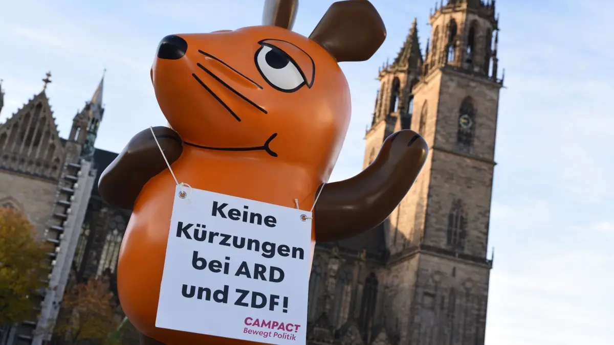 Entführte Figur der „Sendung mit der Maus“ steht in Magdeburg vo: 17.10.2024, Sachsen-Anhalt, Magdeburg: Die von Aktivisten von «Campact e.V.» in Köln entführte Maus aus der «Sendung mit der Maus» steht vor dem Magdeburger Dom auf dem Domplatz, an dem sich auch der Landtag von Sachsen-Anhalt befindet. Die Aktivisten reisen mit der Maus in mehrere deutsche Städte, um ein Zeichen gegen die drastischen Kürzungen im Informations- und Bildungsangebot des öffentlich-rechtlichen Rundfunks (ÖRR) zu setzen. Foto: Simon Kremer/dpa +++ dpa-Bildfunk +++