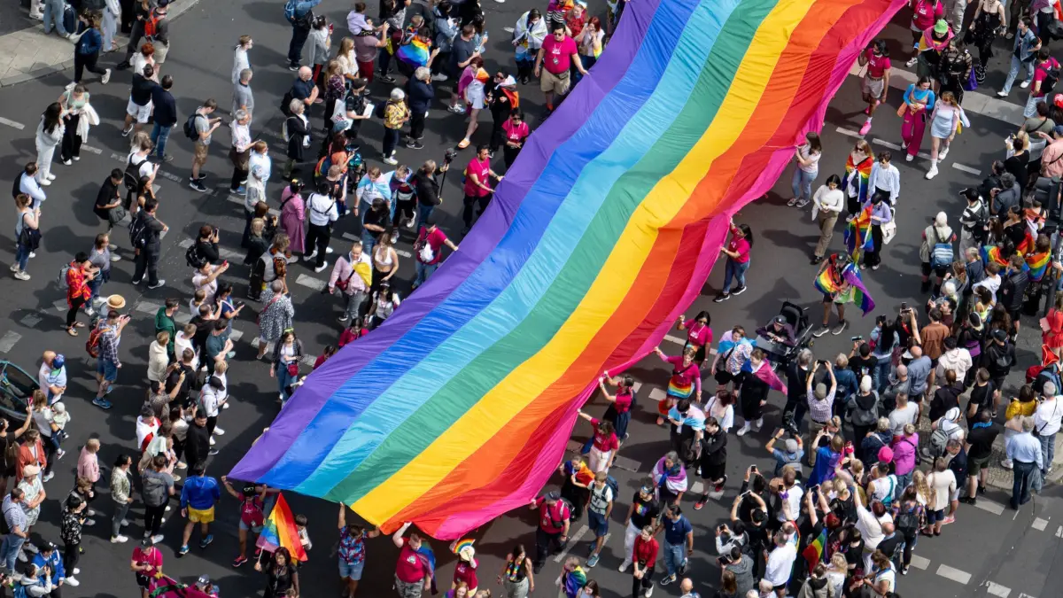 Christopher Street Day Berlin: ARCHIV - 22.07.2023, Berlin: Menschen ziehen auf der 45. Berlin Pride-Parade zum Christopher Street Day (CSD) mit einer überdimensionalen Regenbogenfahne durch die Stadt. Der Berliner CSD ist eine der größten Veranstaltungen der lesbischen, schwulen, bisexuellen, trans-, intergeschlechtlichen und queeren (LGBTIQ) Community in Europa. (zu dpa: «Rechtsextremisten fokussieren sich vermehrt auf queere Szene») Foto: Fabian Sommer/dpa +++ dpa-Bildfunk +++