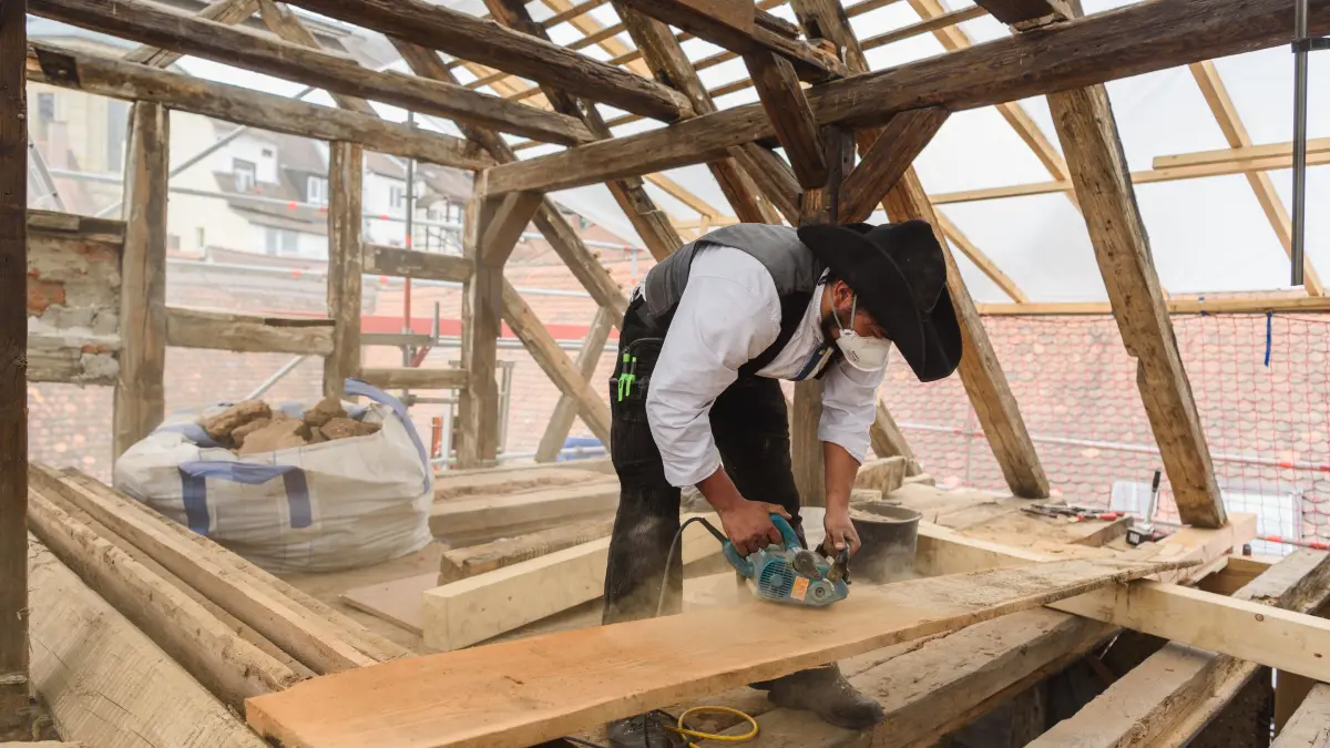 Ein Zimmermannsgeselle arbeitet bei der Sanierung des Baudenkmals Riegelhof. Zimmerer gehören während ihrer Ausbildung zu den Spitzenverdienern unter den Lehrlingen des Handwerks. (zu dpa "Azubis verdienen im Westen im Schnitt knapp 40 Euro mehr als im Osten") +++ dpa-Bildfunk +++
