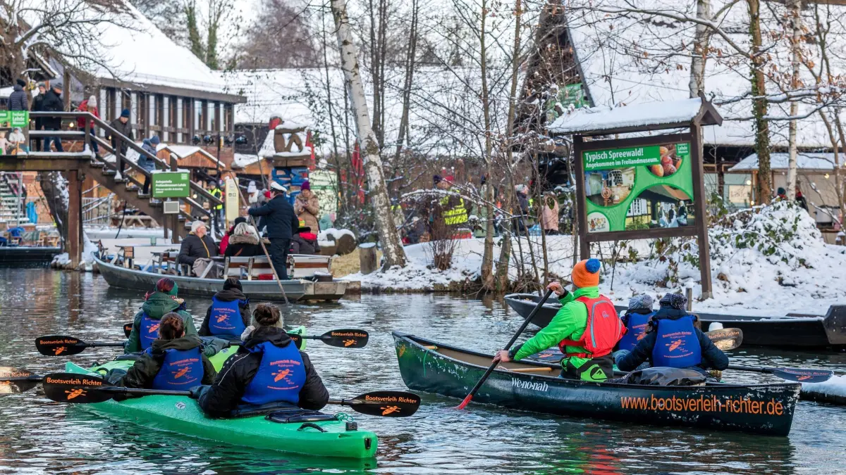 Spreewaldweihnacht: ARCHIV - 02.12.2023, Brandenburg, Lehde: Paddler und Spreewaldkähne erreichen den Hafen des Spreewalddorfes Lehde. Das Freilandmuseum Lehde ist am Samstag Anziehungspunkt für Hunderte Besucher der «Spreewaldweihnacht». Bei der Veranstaltung können die Besucher mit Spreewaldkähnen zu einem Weihnachtsmarkt und zum Freilandmuseum Lehde fahren. (zu dpa: «Sicherheitsfragen sollen Weihnachtsmarkt-Flair nicht trüben») Foto: Frank Hammerschmidt/dpa +++ dpa-Bildfunk +++