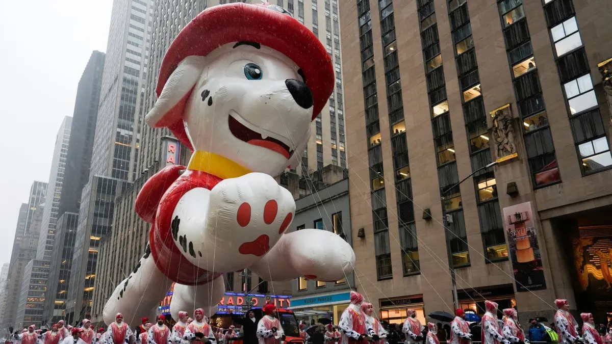 Thanksgiving-Parade in New York: 28.11.2024, USA, New York: Hundeführer führen den Marshall von PAW Patrol-Ballon während der Macy's Thanksgiving Day Parade die Sixth Avenue hinunter. Foto: Julia Demaree Nikhinson/AP +++ dpa-Bildfunk +++
