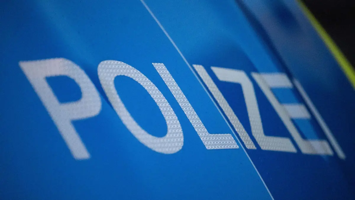 Polizeifahrzeug - Symbolbild: ILLUSTRATION - 30.11.2023, Baden-Württemberg, Stuttgart: Das Wort Polizei ist auf der Karosserie eines Polizeifahrzeugs zu sehen (zu dpa: «Streit zwischen Männern endet mit Schüssen und Unfallflucht») Foto: Marijan Murat/dpa +++ dpa-Bildfunk +++