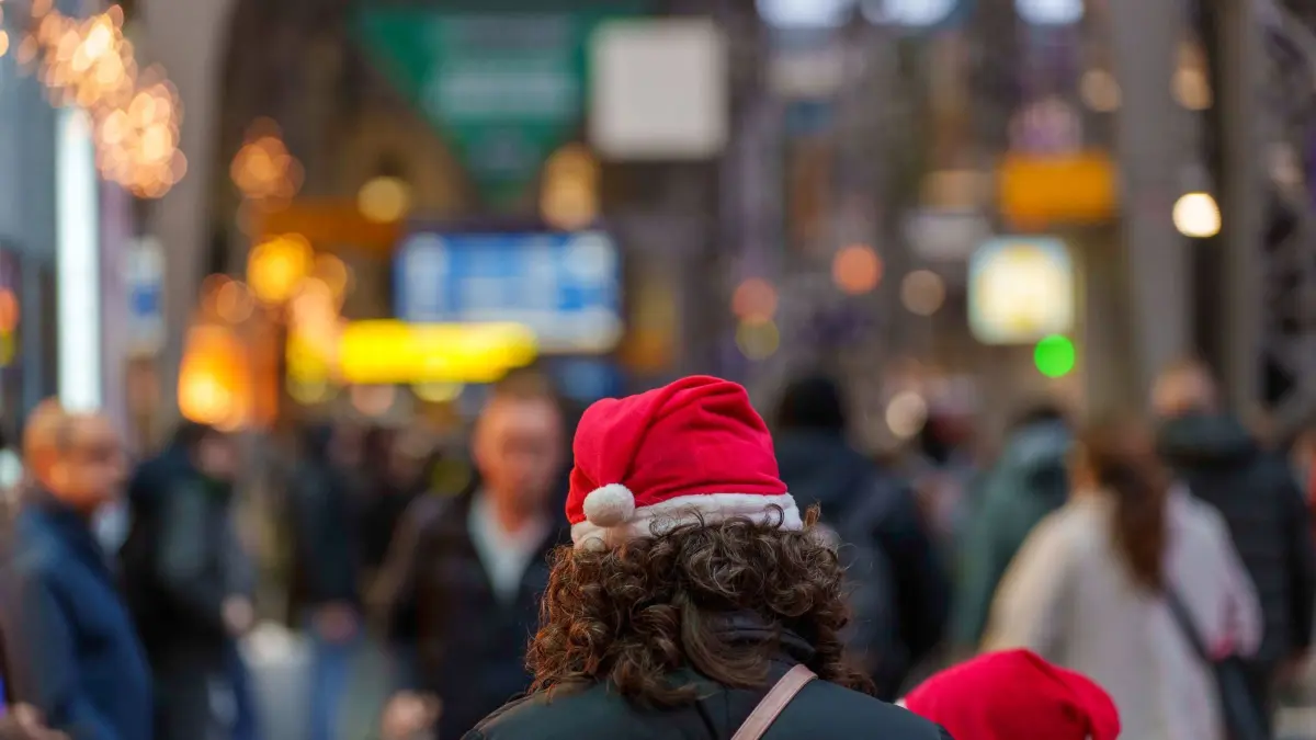 Reiseverkehr zur Weihnachtszeit: ARCHIV - 22.12.2023, Hessen, Frankfurt/Main: Eine Frau steht mit Weihnachtsmütze im Hauptbahnhof. Bahnreisende haben kurz vor Weihnachten noch mit den Folgen von Sturmtief "Zoltan" zu kämpfen. Es kommt zu Verspätungen und Ausfällen. (zu dpa: «Bahn-Chef verteidigt hohe Ticketpreise zu Weihnachten») Foto: Andreas Arnold/dpa +++ dpa-Bildfunk +++