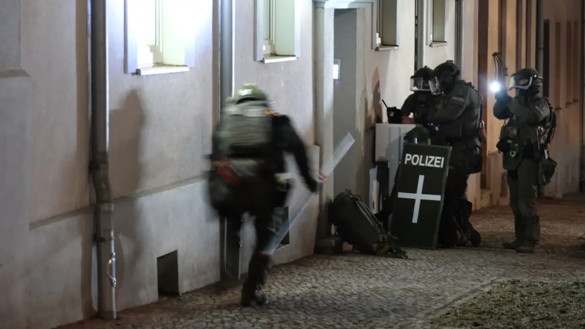 Auto fährt in Menschenmenge auf Magdeburger Weihnachtsmarkt: 21.12.2024, Sachsen-Anhalt, Bernburg: Spezialkräfte der Polizei stehen vor einem Mehrfamilienhaus, das in Zusammenhang mit einer Attacke auf den Weihnachtsmarkt in Magdeburg stehen soll. Auf dem Weihnachtsmarkt in Magdeburg ist ein Autofahrer in eine Menschengruppe gefahren. Foto: Sebastian Willnow/dpa +++ dpa-Bildfunk +++