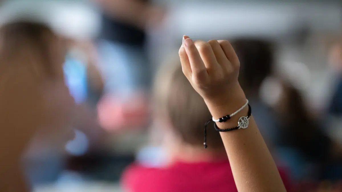 Unterricht an der Grundschule: PRODUKTION - 27.06.2024, Baden-Württemberg, Neckartailfingen: Schülerinnen und Schüler einer vierten Klasse einer Grundschule nehmen am Unterricht teil, eine Schülerin meldet sich. (zu dpa: «126 neue Lehrkräfte starten als Seiteneinsteiger») Foto: Marijan Murat/dpa +++ dpa-Bildfunk +++