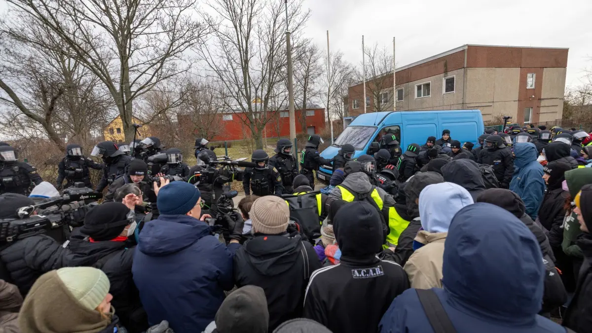 AfD-Parteitag Riesa - Proteste: 11.01.2025, Sachsen, Riesa: Polizisten schaffen Demonstranten von der Straße. Diese wollen den AfD-Parteitag an der WT Energiesysteme Arena Riesa stören. Auf dem Parteitag soll das Bundestagswahlprogramm verabschiedet und die Co-Vorsitzende Weidel als Kanzlerkandidatin aufgestellt werden. Foto: Daniel Wagner/dpa +++ dpa-Bildfunk +++