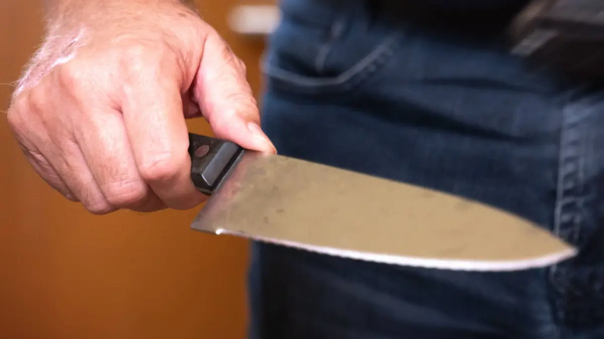 Augsburg, Bayern, Deutschland - 27 Oktober 2023: Mann steht bedrohlich in einer Wohnung mit einem großen Küchenmesser in der Hand. Symbolbild Messerattacke *** Man standing menacingly in an apartment with a large kitchen knife in his hand. Symbol image knife attack