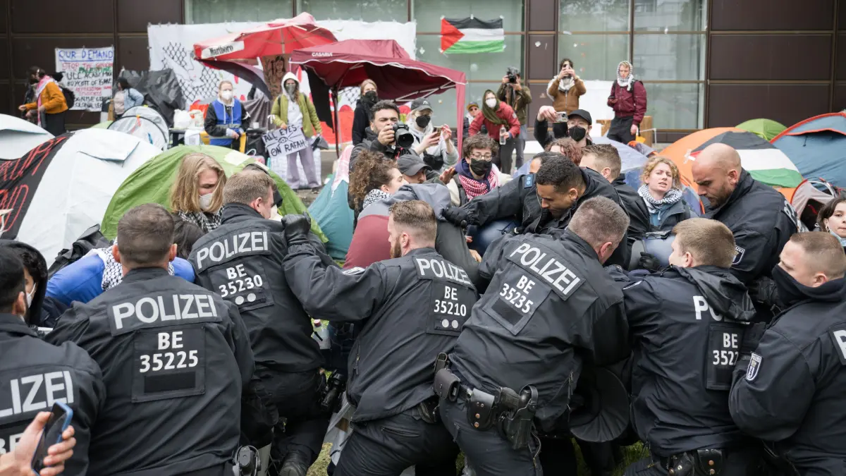 Polizeibeamte gehen während propalästinensischen Demonstration der Gruppe «Student Coalition Berlin» auf dem Theaterhof der Freien Universität Berlin gegen Demonstranten vor. Propalästinensische Aktivisten haben am Dienstag einen Hof der Freien Universität in Berlin besetzt. +++ dpa-Bildfunk +++