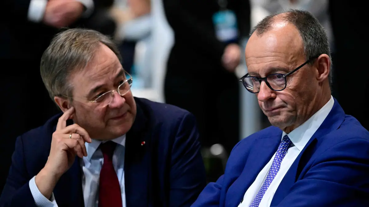 The leader and top candidate for Chancellor of Germany's Christian Democratic Union (CDU) Friedrich Merz (R) speaks with former CDU leader and former candidate for Chancellor Armin Laschet during the CDU Party Congress at the City Cube event location in Berlin, on February 3, 2025. Germany's parliamentary elections are due to take place on February 23, 2025. (Photo by John MACDOUGALL / AFP)