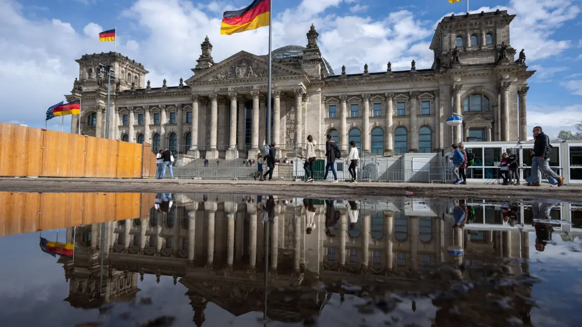 Reichstag: ARCHIV - 05.04.2024, Berlin: Passanten gehen beim sonnigen Wetter an dem Reichstagsgebäude vorbei. (zu dpa: «Von XL auf L - neues Wahlrecht lässt Bundestag schrumpfen») Foto: Monika Skolimowska/dpa +++ dpa-Bildfunk +++