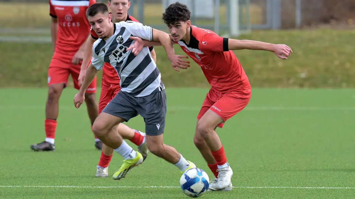 Fussball A Jgd. | SSV Reutlingen U19 vs. SV Sandhausen U19: Fussball A-Jgd. / DFB-Nachwuchsliga | SSV Reutlingen U19 (rot) vs. SV Sandhausen U19 (weiss) // 2025-02-23 // Foto: Joachim Baur // #3 Giuliano Iannuzzi (SSV Reutlingen U19), re / #2 Dimitrios Radis (SV) / #16 Elkana Maier (SSV Reutlingen U19), mitte