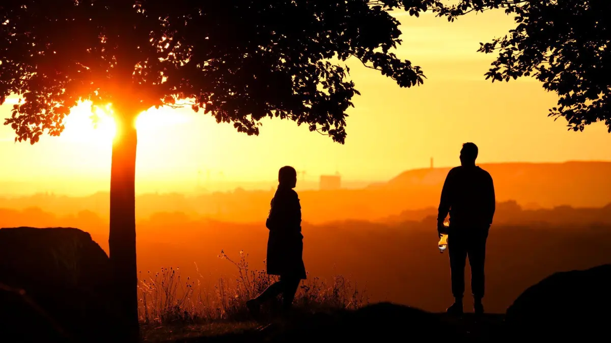 Sonnenaufgang in Hannover: ARCHIV - 05.09.2023, Niedersachsen, Hannover: Ein Paar steht bei Sonnenaufgang auf dem Kronsberg. (zu dpa: «Umfrage zur Klimakrise: Viele Paare sorgen sich um Zukunft») Foto: Julian Stratenschulte/dpa +++ dpa-Bildfunk +++