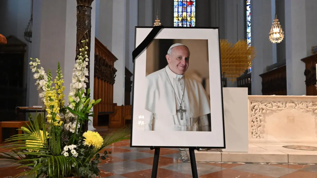 Papst Franziskus gestorben - München: 21.04.2025, Bayern, München: Ein Bild von Papst Franziskus steht in der Nähe des Altars der Frauenkirche, dem Münchner Dom. Der Papst ist am Ostermontag im Alter von 88 Jahren gestorben. Foto: Felix Hörhager/dpa - ACHTUNG: Nur zur redaktionellen Verwendung im Zusammenhang mit der aktuellen Berichterstattung und nur mit vollständiger Nennung des vorstehenden Credits +++ dpa-Bildfunk +++