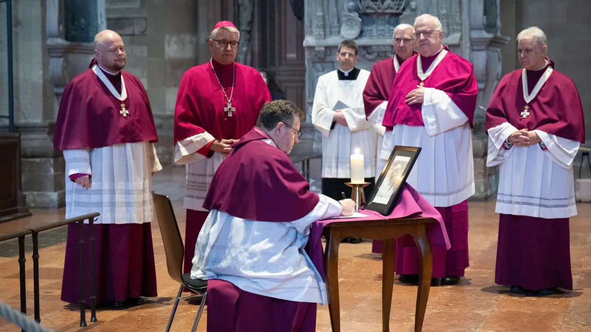 Papst Franziskus gestorben - Mainz: 21.04.2025, Rheinland-Pfalz, Mainz: Kirchliche Würdenträger, darunter der Mainzer Bischof Peter Kohlgraf (2.v.l.), tragen sich im Dom nach einem Gottesdienst für den verstorbenen Papst in das Kondolenzbuch ein. Das Oberhaupt der Katholischen Kirche war am Morgen im Vatikan verstorben. Foto: Boris Roessler/dpa +++ dpa-Bildfunk +++