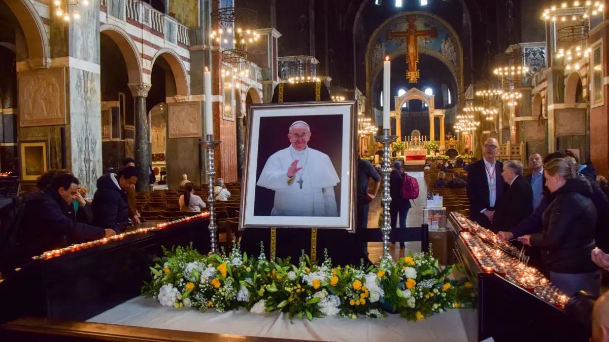 Papst Franziskus gestorben - London: 21.04.2025, Großbritannien, London: Menschen zünden neben einem Bild von Papst Franziskus in der Westminster Cathedral Kerzen an, nachdem der Vatikan den Tod von Papst Franziskus bekanntgegeben hat. Foto: Vuk Valcic/ZUMA Press Wire/dpa +++ dpa-Bildfunk +++