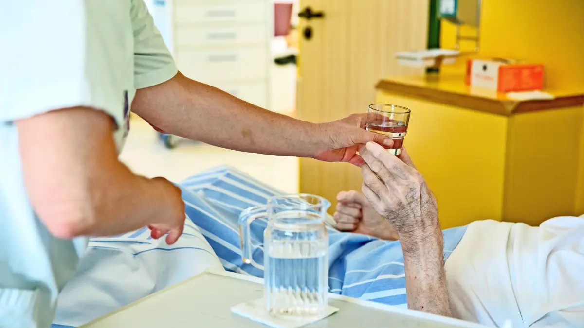 ARCHIV - 01.07.2015, ---: ILLUSTRATION - Eine Krankenpflegerin reicht einem Patienten in einem Klinikum ein Glas Wasser. Der drohende Brexit beunruhigt viele EU-Bürger, die in Großbritannien arbeiten. Davon will nun die Uniklinik Düsseldorf profitieren. In Anzeigen in zwei polnischsprachigen britischen Zeitungen warb das Krankenhaus diese Woche unter der Überschrift: «Brexit-Sorgen? «Kommen Sie nach Deutschland!» um Pflegekräfte. (zu dpa «Uni-Klinik wirbt in Großbritannien um Pflegekräfte mit Brexit-Ängsten» vom 08.02.2019) Foto: Daniel Karmann/dpa +++ dpa-Bildfunk +++