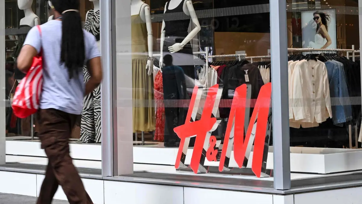 People walk past an H&M (Hennes & Mauritz) store on July 15, 2025, in New York City. US consumer inflation picked up in line with analyst expectations in June, government data showed on July 15, 2025, with vehicle costs cooling over the month but increases seen in sectors exposed to President Donald Trump's widening slate of tariffs. Observers anticipate they will learn more about the effects of Trump's duties over the summer months, meaning June's data marks the start in a series of closely-watched figures -- particularly as the central bank mulls changes to interest rates. The consumer price index (CPI) was up 2.7 percent from a year ago in June, climbing from 2.4 percent in May as energy costs rose, said the Department of Labor. (Photo by ANGELA WEISS / AFP)