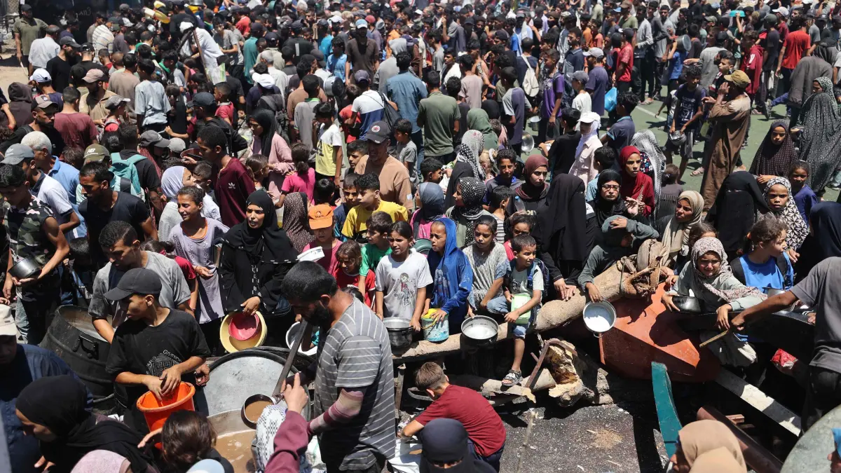 Palestinians gather at a food distribution point in the Nuseirat refugee camp in the central Gaza Strip on July 19, 2025. The World Food Programme said nearly one in three people in Gaza were not eating for days at a stretch and "thousands" were "on the verge of catastrophic hunger". (Photo by Eyad BABA / AFP)