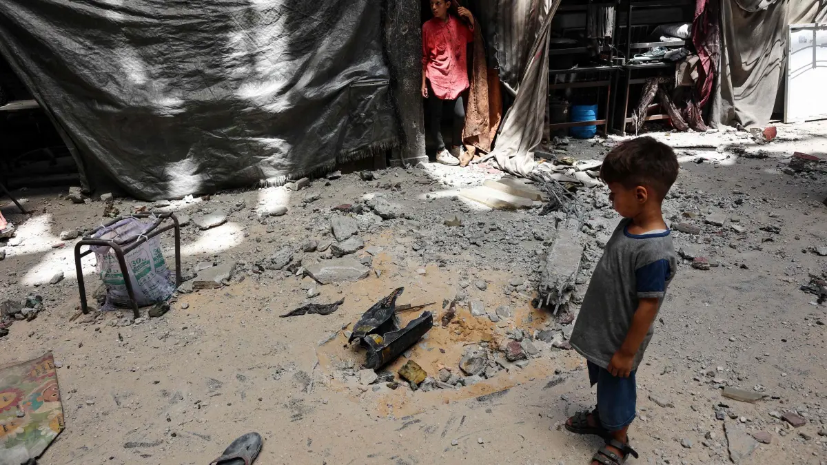 A displaced Palestinians boy stands near a bomb crater following an Israeli strike that hit a school-turned shelter in the Rimal neighbourhood of Gaza City on July 25, 2025. (Photo by Omar AL-QATTAA / AFP)