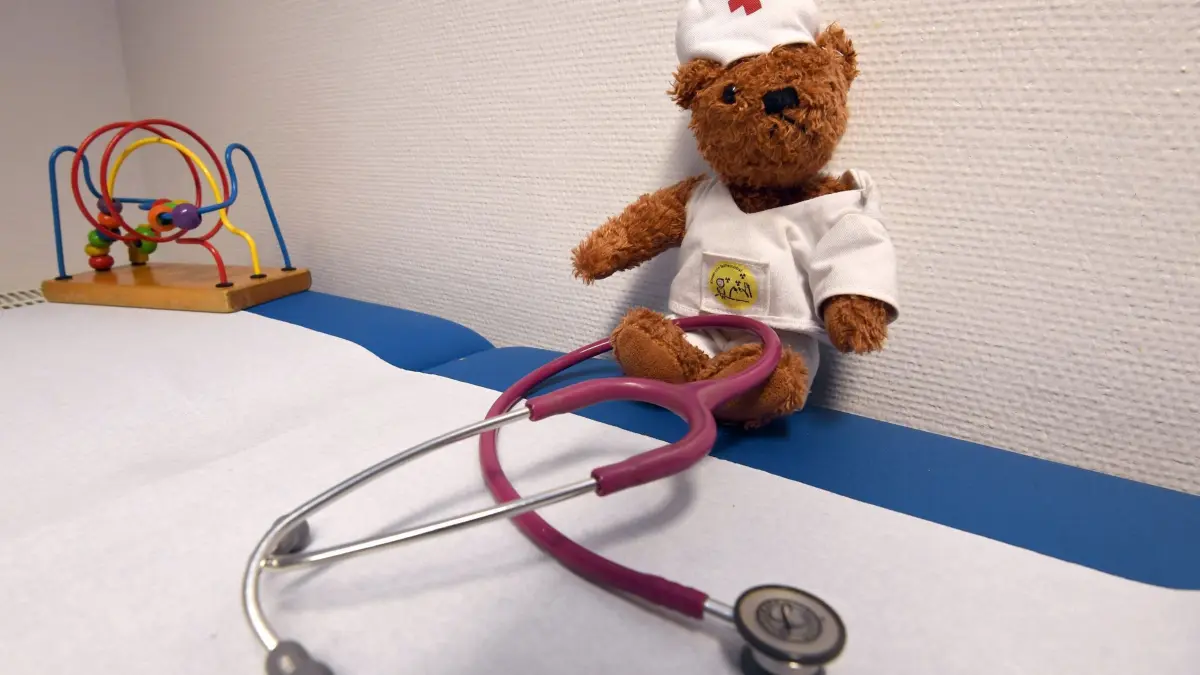 Kinderarzt: ARCHIV - 13.12.2018, Niedersachsen, Syke: ILLUSTRATION - Ein Stethoskop liegt in der Praxis einer Kinderärztin vor einem als Arzt verkleideten Teddy auf einer Liege. Kinder und Jugendliche in MV sind häufiger krank als ihre Altersgenossen in anderen Bundesländern. Fast ein Drittel ist chronisch krank. Erstaunlich sind die Unterschiede zwischen Stadt und Land. Die Ursachen benennt die Studie nicht. (zu dpa: «Darum ist das Schütteln von Babys so gefährlich») Foto: Carmen Jaspersen/dpa +++ dpa-Bildfunk +++