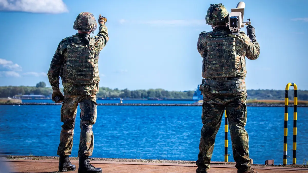 Bundeswehr-Übungsserie „Quadriga 2025“: 04.09.2025, Mecklenburg-Vorpommern, Rostock: Spezialkräfte der Bundeswehr wehren bei einem Übungsszenario im Hafen den Anflug von unbekannten Flugdrohnen ab. Die Soldaten sichern das 196 Meter lange Transportschiffs «Ark Germania» beim Beladen mit Militärtechnik im Hafengebiet ab. Im Rahmen des Militär-Manövers «Quadriga 2025» werden über 1.000 Militärfahrzeuge auf dem Seeweg nach Litauen transportiert. In diesem Jahr steht die Dimension See mit der Sicherung und dem Schutz von strategischen Seewegen und Infrastrukturen im Mittelpunkt der Übungsserie «Quadriga». Foto: Jens Büttner/dpa +++ dpa-Bildfunk +++
