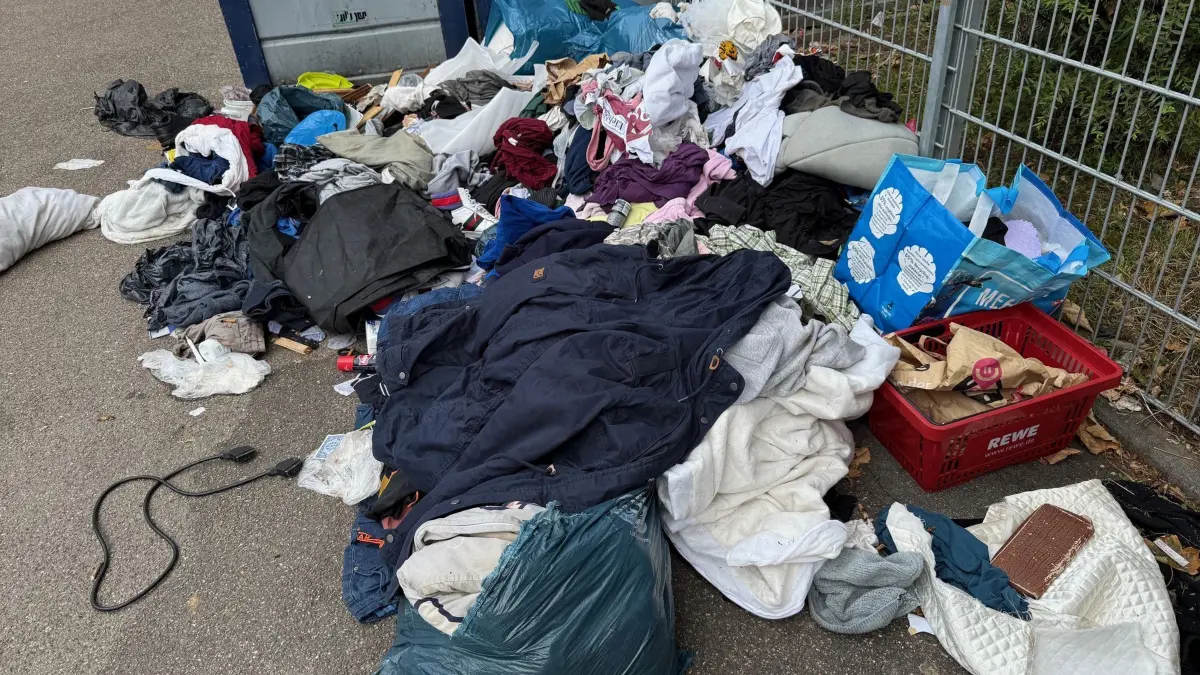 Altkleider liegen vor Altglascontainern: PRODUKTION - 03.09.2025, Baden-Württemberg, Stuttgart: Altkleider und Abfall liegen vor Altglascontainern in der Nähe eines Spielplatzes. Bis vor kurzem stand an der Stelle noch ein Sammelcontainer für Altkleider. (zu dpa: «Altkleidercontainer verschwinden – Hilfswerke schlagen Alarm») Foto: Marco Krefting/dpa +++ dpa-Bildfunk +++