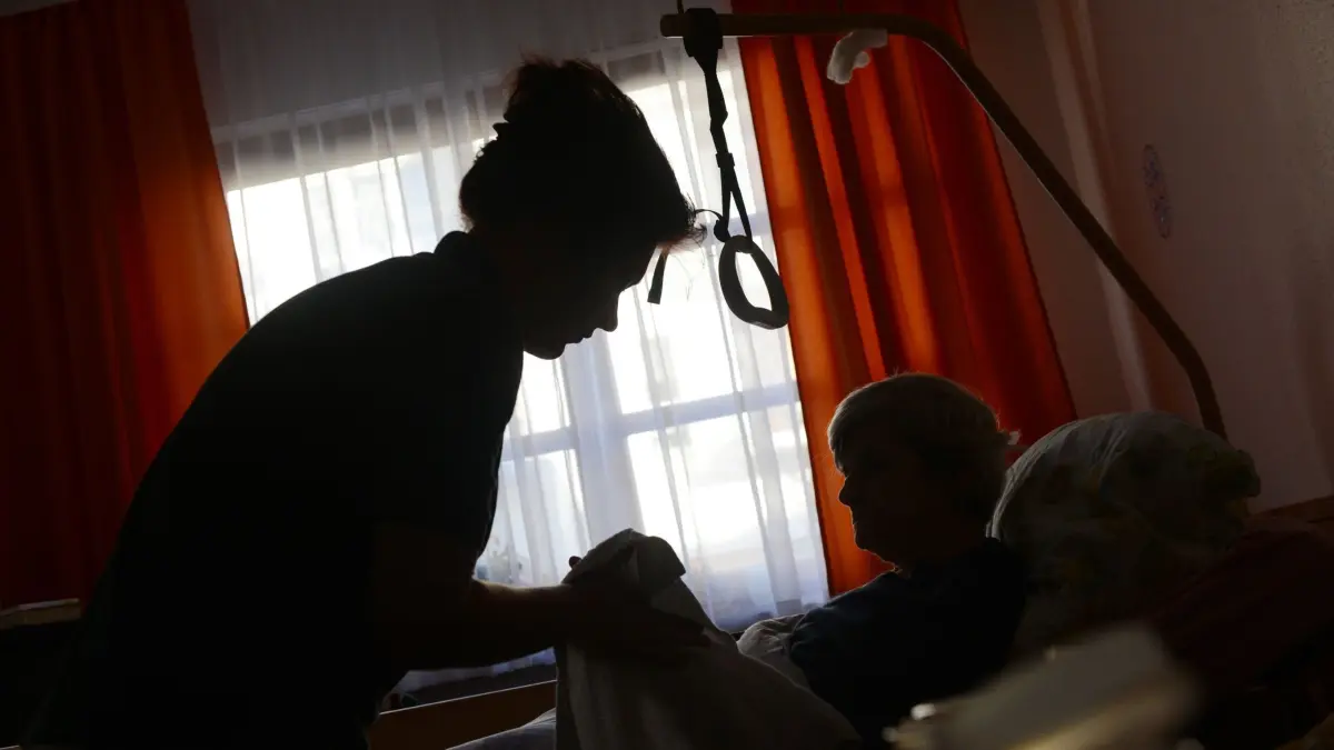 Pflegerin kümmert sich um eine Seniorin: ARCHIV - Pflege und Ansprache: Wer mit Patienten arbeitet, braucht Fachwissen und Einfühlungsvermögen. (zu dpa: «Arbeit in der Pflege: Welche Stärken es braucht») Foto: Jens Kalaene/dpa-Zentralbild/dpa-tmn - Honorarfrei nur für Bezieher des dpa-Themendienstes +++ dpa-Themendienst +++