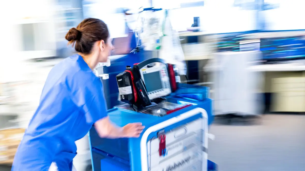 ARCHIV - 12.05.2025, Bremen: Eine Mitarbeiterin auf der Intensivstation vom Diako-Klinikum im Stadtteil Gröpelingen schiebt einen Wagen mit einem Defibrillator zu einem Notfall. (zu dpa: «So sollen Kliniken auf den Krisenfall vorbereitet werden») Foto: Sina Schuldt/dpa +++ dpa-Bildfunk +++