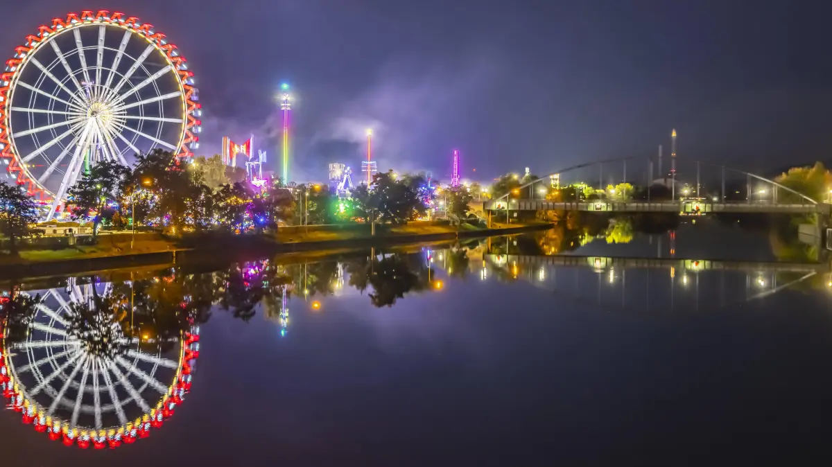 Volksfest in Stuttgart. Das 178. Cannstatter Volksfest auf dem Wasen zählt zu den bedeutendsten Traditionsfesten in Deut: Volksfest in Stuttgart. Das 178. Cannstatter Volksfest auf dem Wasen zählt zu den bedeutendsten Traditionsfesten in Deutschland. Im Neckar spiegeln sich Riesenrad und andere Attraktionen des Vergnügungsparks. // 09.10.2025. Stuttgart, Baden-Württemberg, Deutschland *** Volksfest in Stuttgart The 178 Cannstatter Volksfest on the Wasen is one of the most important traditional festivals in Germany The Neckar River reflects the Ferris wheel and other attractions of the amusement park 09 10 2025 Stuttgart, Baden Württemberg, Germany