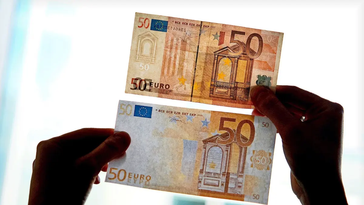 ARCHIV - 31.03.2011, NA, Berlin: Ein echter und ein falscher Fünfzig-Euro-Schein werden gegen das Licht gehalten. Laut Bundeskriminalamt wird Falschgeld immer häufiger im Internet gehandelt. In Berlin sollen Mutter und Sohn auf diese mehrere Hundert Euro gekauft und unter das Geld einer pflegebedürftigen Frau gemischt haben. Sie sollen nun vor Gericht kommen. (zu dpa: «Mutter und Sohn angeklagt - Falschgeld im Internet gekauft?») Foto: Franziska Gabbert/dpa-Zentralbild/dpa +++ dpa-Bildfunk +++