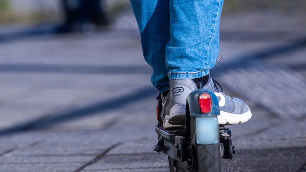 ARCHIV - 17.04.2024, Mecklenburg-Vorpommern, Wismar: Ein Reisender fährt mit seinem E-Scooter über den Bahnsteig. (zu dpa: «E-Scooter-Fahrer nach Sturz schwer verletzt») Foto: Jens Büttner/dpa +++ dpa-Bildfunk +++