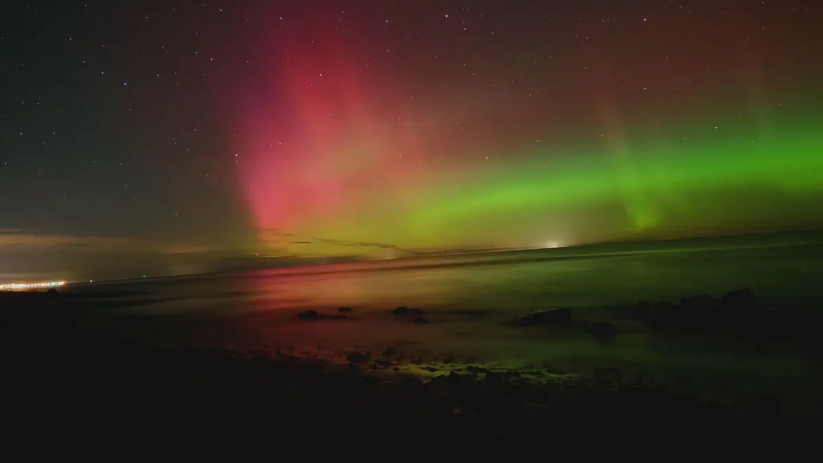 Rote und grüne Nordlichter am Strand von Heiligendamm in MV