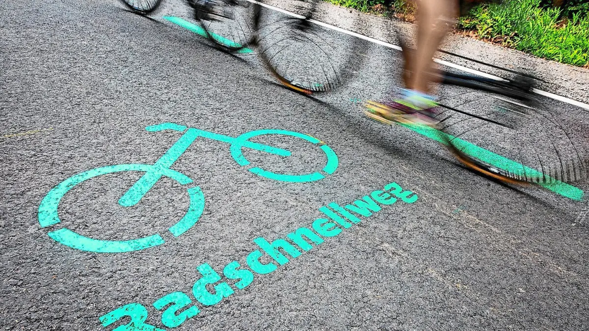 ARCHIV - 31.05.2019, Baden-Württemberg, Böblingen: Radfahrer fahren nach der Eröffnung des Radschnellwegs zwischen Böblingen/Sindelfingen und Stuttgart an einer Aufschrift auf dem Asphalt vorbei. Der erste Radschnellweg in Baden-Württemberg ist am 31.05.2019 für den Verkehr freigegeben worden. (zu dpa: «6,4 Millionen Euro vom Bund für weitere Radschnellwege») Foto: Christoph Schmidt/dpa +++ dpa-Bildfunk +++