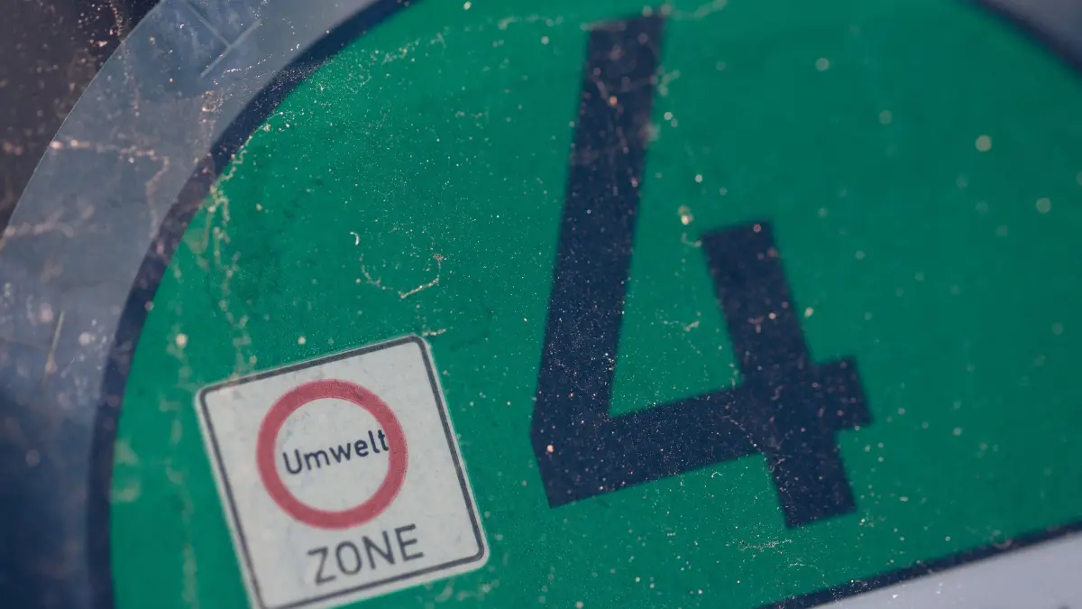 Umweltplakette: ARCHIV - 10.10.2021, Berlin: Eine Euro 4 Plakette ist auf der Windschutzscheibe eines Autos zu sehen. Eine grüne Feinstaubplakette erhalten Fahrzeuge der Schadstoffklasse 4. Mit dieser Umweltplakette dürfen alle Umweltzonen ohne Einschränkung befahren werden. (zu dpa: «Umweltplakette für E-Autos soll wegfallen») Foto: Fernando Gutierrez-Juarez/dpa-Zentralbild/dpa +++ dpa-Bildfunk +++