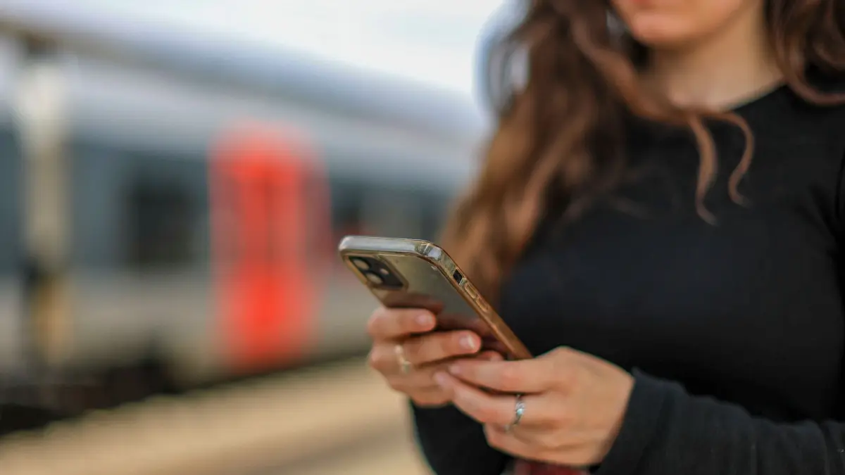 Eine junge Frau steht mit ihrem Mobiltelefon auf einem Bahnsteig: ARCHIV - Der Abstand macht den Unterschied: Wer lieber textet, oder beim Telefonieren die Freisprechfunktion nutzt, verringert die Strahlenbelastung deutlich. (zu dpa: «Wer strahlt weniger? - Wo sich Handys unterbieten sollten») Foto: Jan Woitas/dpa/dpa-tmn - Honorarfrei nur für Bezieher des dpa-Themendienstes +++ dpa-Themendienst +++